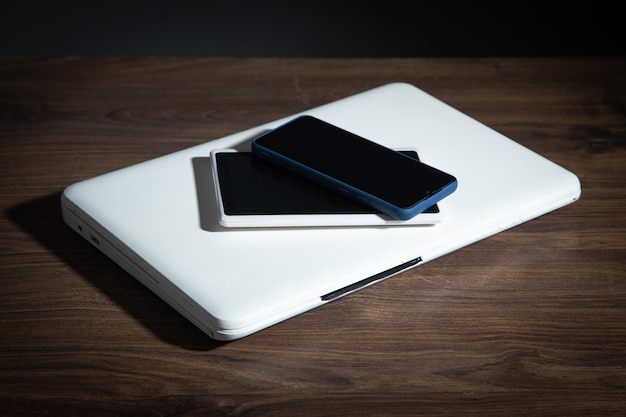 Computer portatile della compressa di smartphone sulla tavola di legno