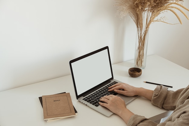 Computer portatile dello schermo in bianco al concetto di affari di casa