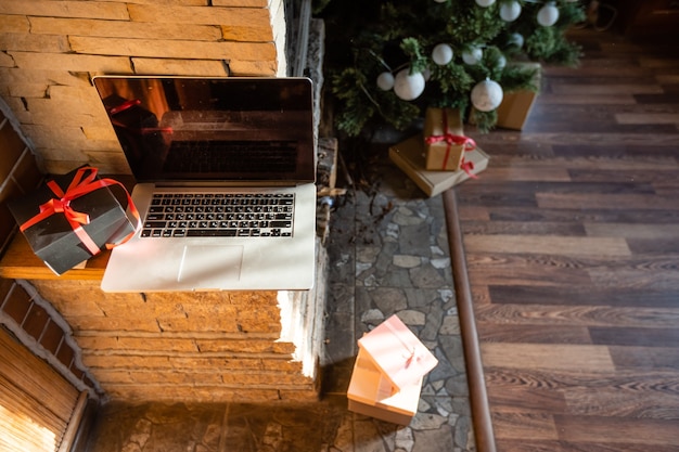 Computer portatile di Natale con albero di Natale in una vecchia casa di legno