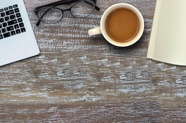 Computer portatile e occhiali e caffè caldo e libro vuoto