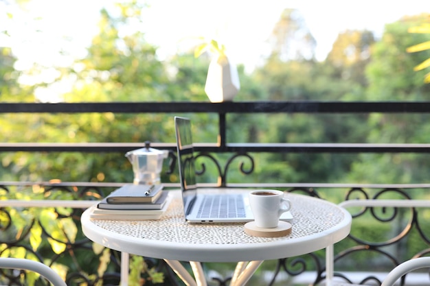 Computer portatile e tazza da caffè con moka su tavolo di metallo