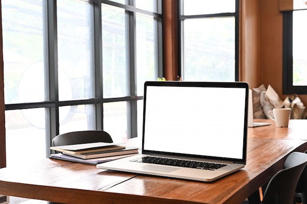 Computer portatile sul tavolo di lavoro con una scrivania di legno.