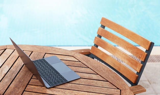 Computer portatile sul tavolo vicino alla piscina con spazio di copia Concetto di lavoro e viaggio con spazio di copia