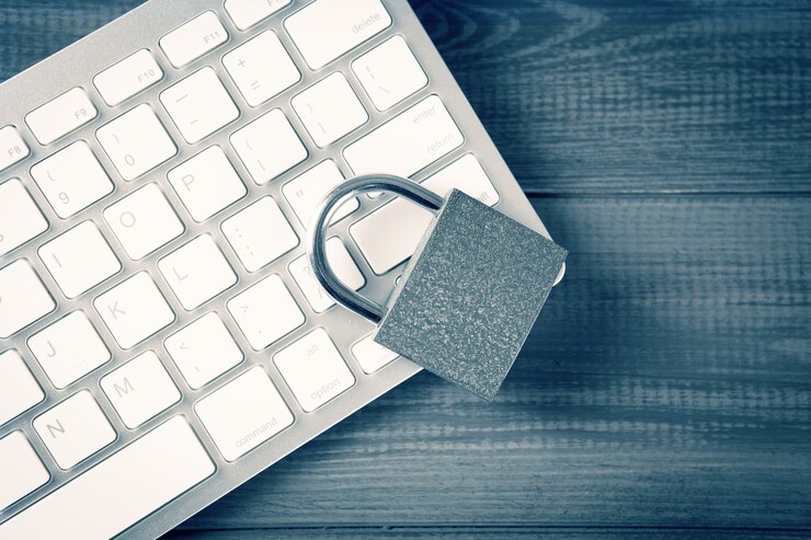 Photo computer security concept. unlocked padlock on laptop keyboard. safe symbol. selective focus on gray wooden table