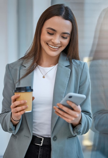 Comunicazione della donna d'affari al telefono con l'app dei social media Web Internet Technology e pausa caffè in una società di avvio Sorriso felice e contenuto impiegato che legge una notifica mobile divertente