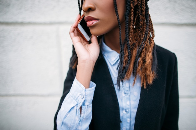 Comunicazioni moderne. Primo piano di bellezza di moda. Ritratto di ragazza nera irriconoscibile, donna afroamericana su sfondo bianco, concetto di tecnologia