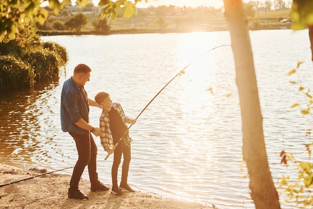 Con cattura Padre e figlio a pescare insieme all'aperto in estate