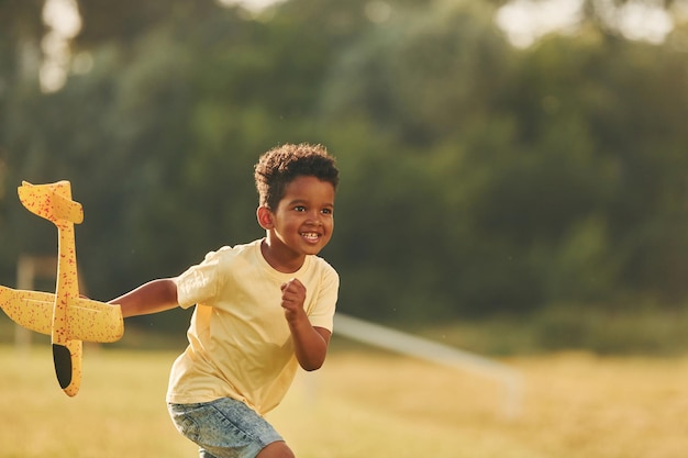 Con il giocattolo in mano Il bambino afroamericano si diverte nel campo durante il giorno d'estate