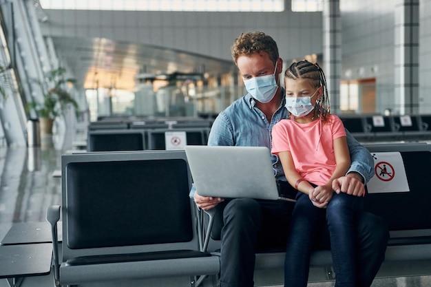 Con la bambina Giovane uomo in abbigliamento formale è in aeroporto moderno