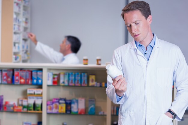 Concentrando l&#39;etichetta della lettura del farmacista sul barattolo della medicina