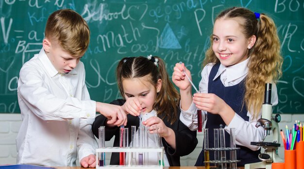 Concentrandosi sul lavoro Bambini piccoli in laboratorio Studenti che fanno esperimenti di biologia con il microscopio Microscopio da laboratorio Giornata dei bambini Microscopio chimico Bambini piccoli che imparano la chimica nel laboratorio scolastico