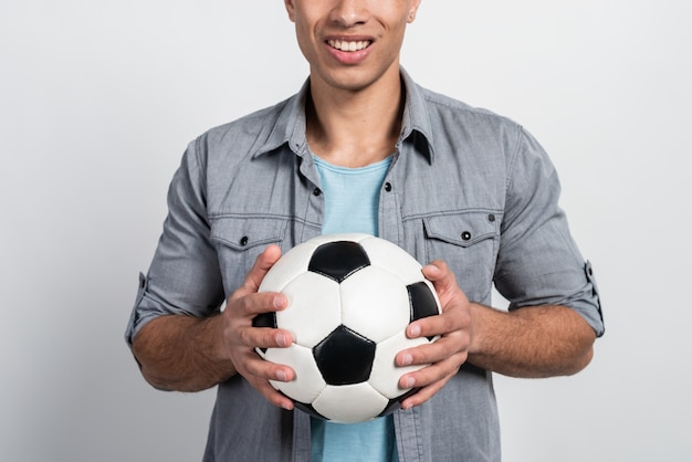 Concentrarsi su un pallone da calcio nelle mani maschili