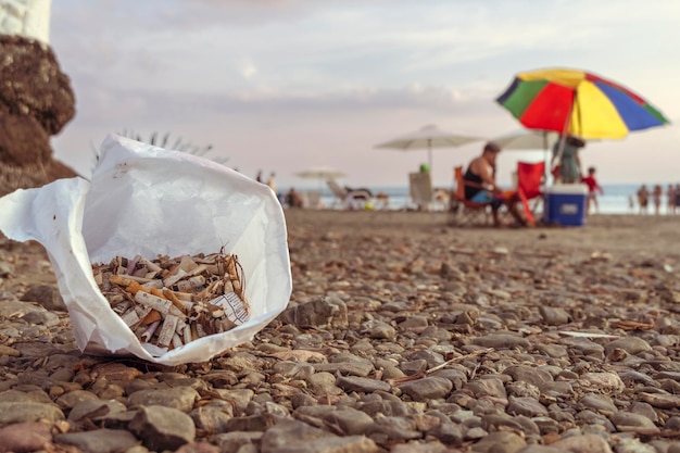 Concentrarsi sulle sigarette in primo piano spiaggia sullo sfondo Concetto di ecologia e Giornata mondiale dell'ambiente