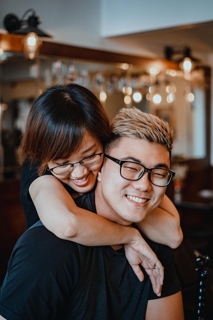 Concentrati due coppie di innamorati asiatici guardano insieme e ammirano la bellissima caffetteria romantica