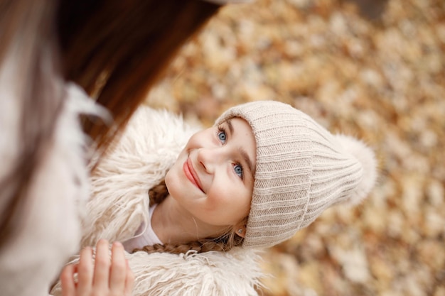 Concentrati sul viso di una ragazza felice. La donna gioca con sua figlia. Ragazza che indossa un maglione beige.