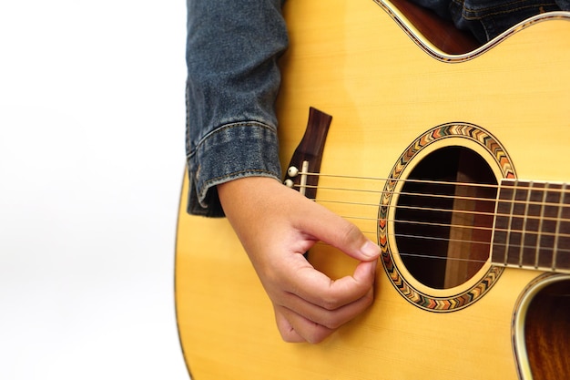 Concentrati sulle mani del bambino o dell'adolescente che suona la chitarra acustica. Concetto di apprendimento e relax