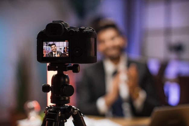 Concentrati sullo schermo della fotocamera di un uomo d'affari barbuto qualificato arabo di successo sorridente