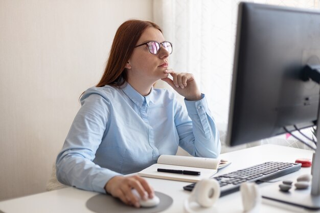 Concentrato donna caucasica americana che lavora e utilizza il computer in ufficio.