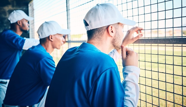 Concentrazione sportiva e baseball con l'uomo in panchina per pensare all'allenamento e pianificare la strategia Rilassare il lavoro di squadra e l'allenamento con un gruppo di persone nello stadio del parco per la partita o l'allenamento della competizione di fitness