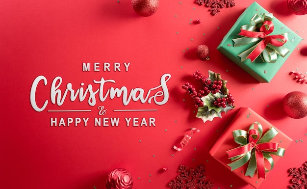 Concept di sfondo di Natale e Capodanno Vista superiore della decorazione natalizia fatta di scatola regalo, fiocco di neve, palla di natale e rami di pino su sfondo rosso