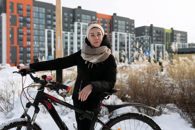 Concept di stile di vita giovane donna che guida una bicicletta sportiva in inverno