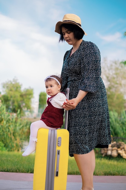 Concept di viaggio madre e figlia con una valigia si stanno preparando per un viaggio un bambino si siede
