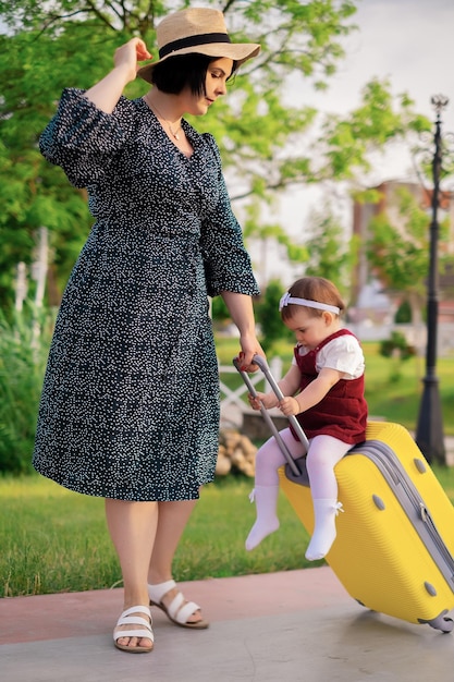 Concept di viaggio madre e figlia con una valigia si stanno preparando per un viaggio un bambino si siede