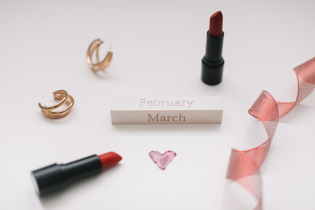 Concept Womens Day 8 marzo Rossetti cosmetici prodotti per il trucco e accessori flatlay vista dall'alto