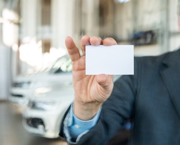 Concessionario di auto che mostra il suo biglietto da visita