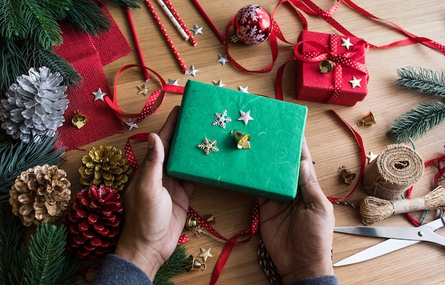 Concetti di buon Natale con mano umana che decora confezione regalo presente