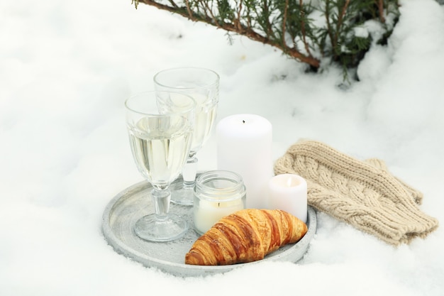 Concetto accogliente con champagne e croissant all'aperto in inverno