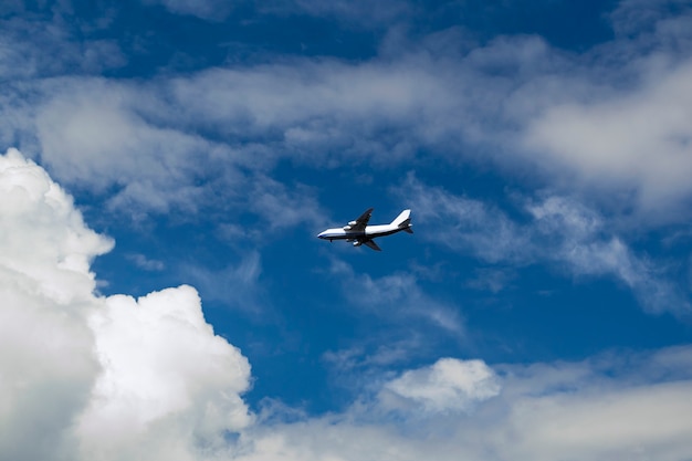 Concetto aereo su un cielo blu tra nuvole bianche e luce solare che sta volando un aereo passeggeri o cargo