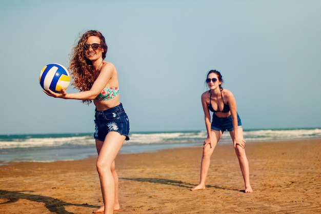 Concetto allegro degli amici di estate delle donne della spiaggia di pallavolo