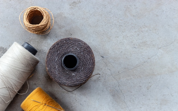 Concetto artigianale e fai-da-te. fili per cucire sul pavimento di cemento. vista dall&#39;alto