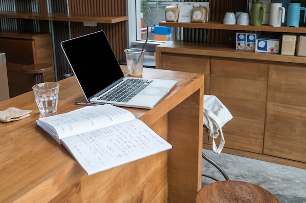 Concetto astratto di lavoro al caffè con laptop e notebook sul tavolo di legno