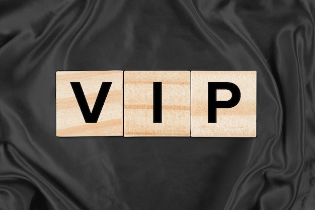 Concetto aziendale VIP Piastrelle in legno che precisano VIP in cima a sfondo di seta nera