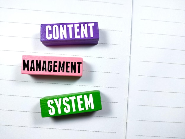 Concetto aziendaleTesto SISTEMA DI GESTIONE DEI CONTENUTI che scrive su un blocco di legno colorato su un notebook