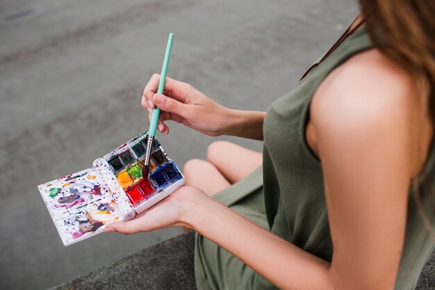 Concetto creativo della donna variopinta dell'artista degli inchiostri. Illumina la routine grigia. Stile di vita di un pittore.