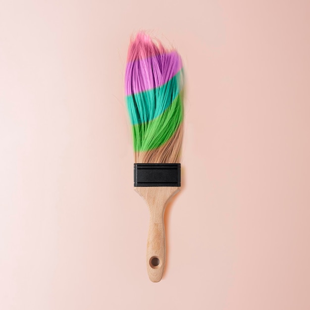 Concetto creativo di colorazione dei capelli Pennello con capelli femminili multicolori su sfondo pescozzo pastello Vista superiore