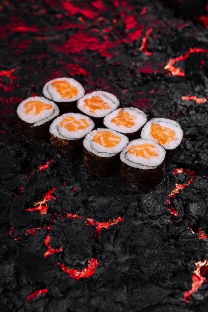 Concetto creativo di rotoli di sushi su uno sfondo di lava fiammeggiante