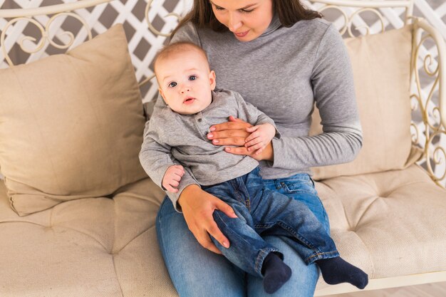 Concetto del bambino e del bambino - bambino curioso che guarda alla macchina fotografica.