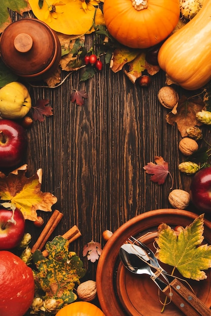 Concetto del giorno del Ringraziamento Sfondo autunnale da foglie e frutti caduti con tavolo vintage su vecchio tavolo di legno