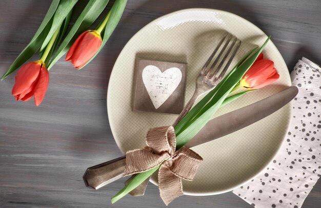 Concetto del menu di primavera con i tulipani e la decorazione freschi del cuore su legno