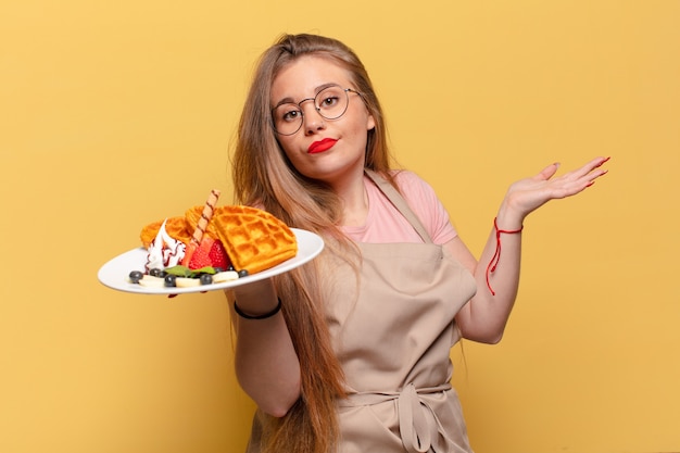 Concetto del panettiere di espressione confusa della giovane donna graziosa