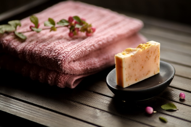 Concetto del sapone organico, regalo fatto a mano, barra di sapone rosa contro fondo di legno, fine su