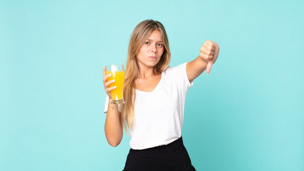 Concetto del succo d'arancia della donna bionda abbastanza giovane?