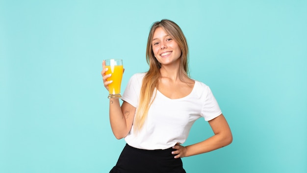 Concetto del succo d'arancia della donna bionda abbastanza giovane?