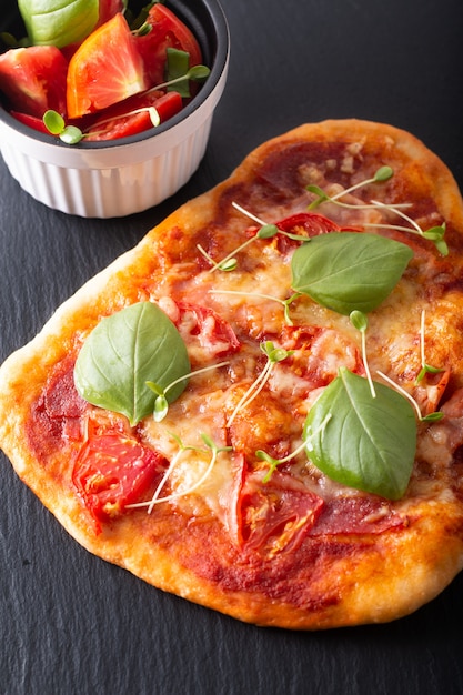 Concetto dell'alimento Pizza organica casalinga con il pomodoro, il basilico e il prosciutto con lo spazio della copia
