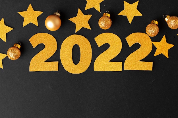 Concetto dell'anno 2022. Stelle d'oro e numeri 2022 su carta nera