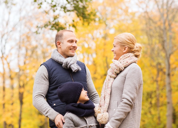 Concetto della famiglia, dell'infanzia, di stagione e della gente - famiglia felice nel parco di autunno